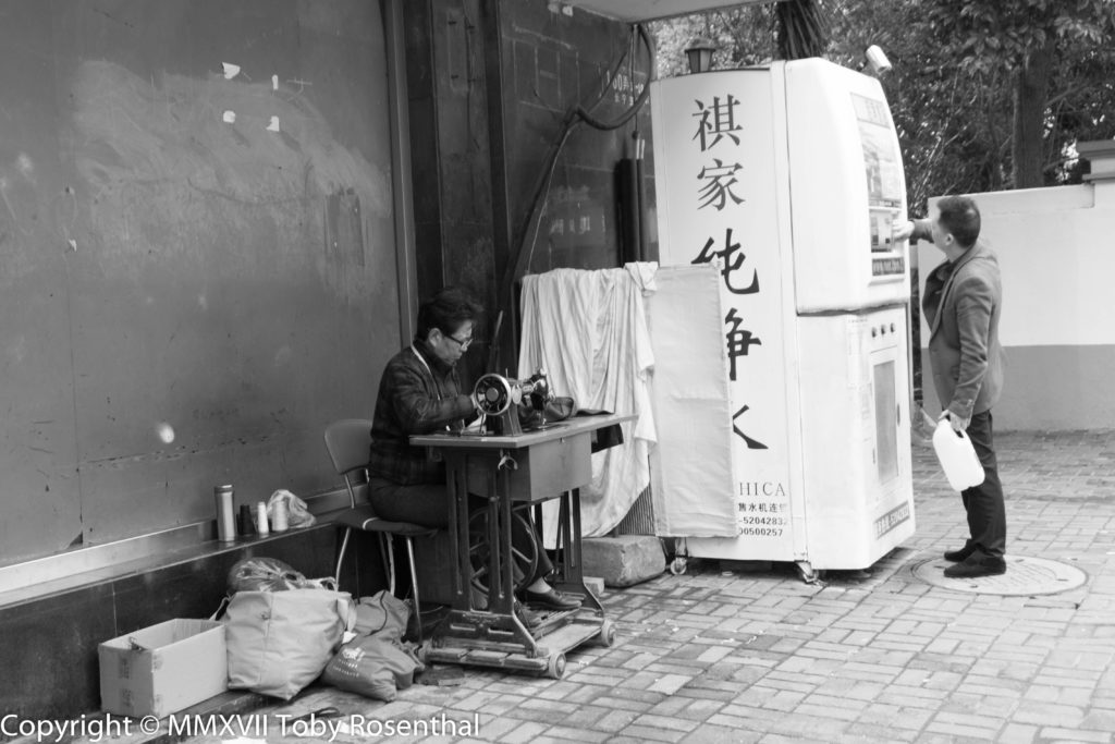 Street Photography A Taylor And A Water Dispenser